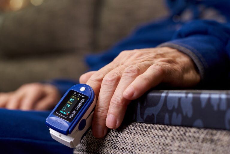 Pulse oximeter on the hands of an elderly woman